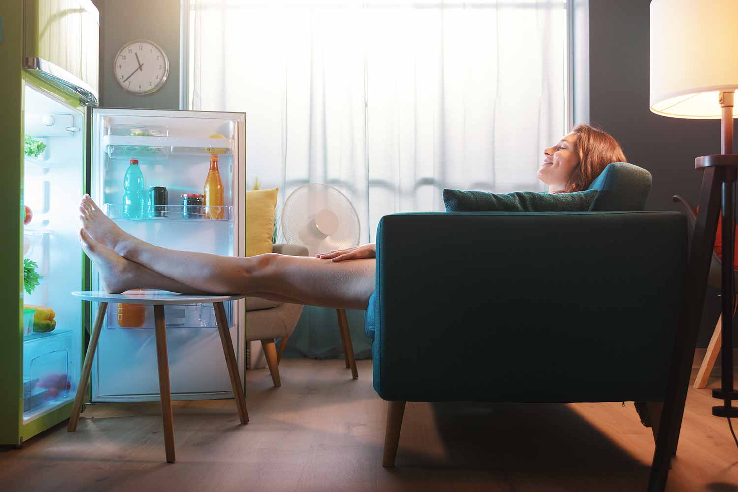 woman cooling her feet in a fridge