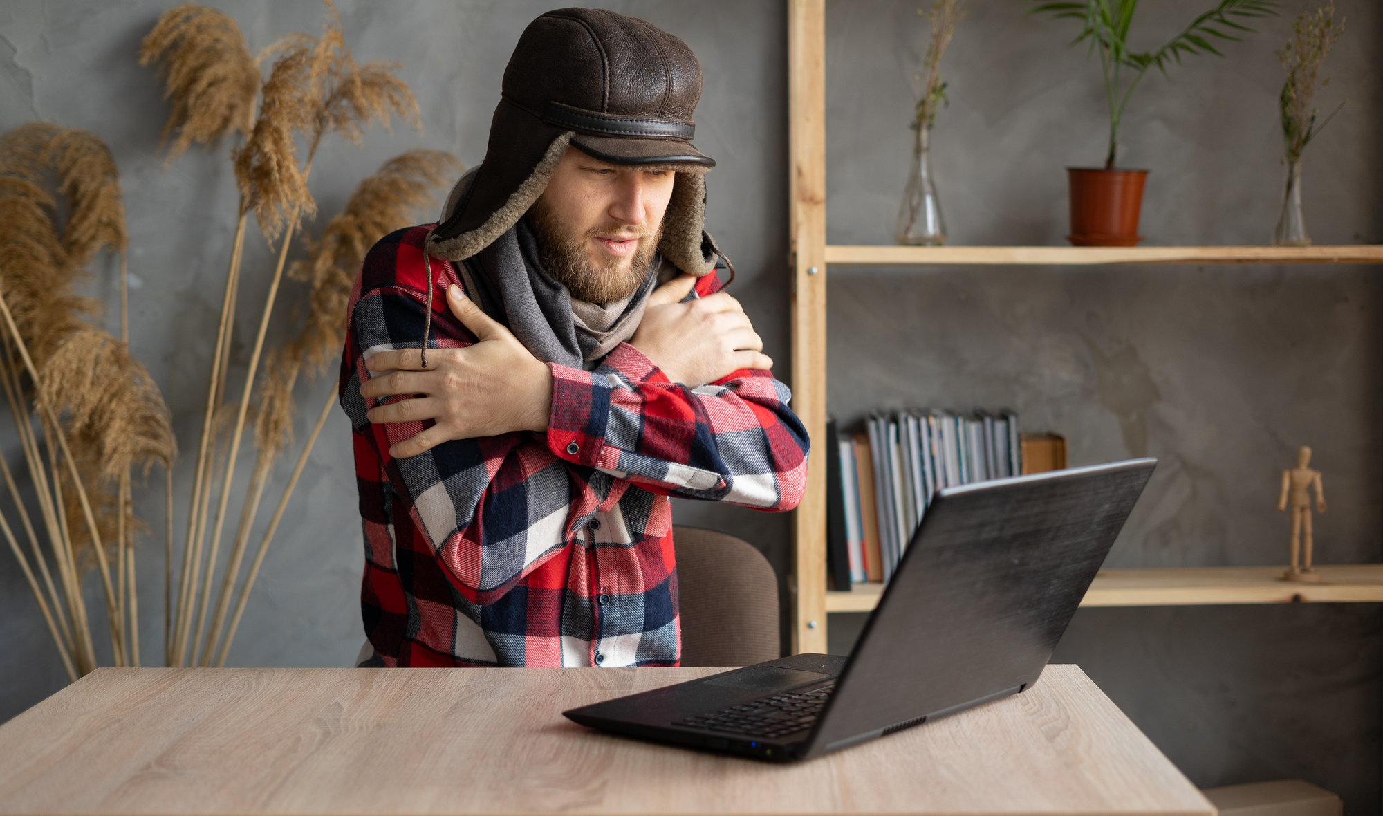 Young male feeling cold because of the furnace not working properly.