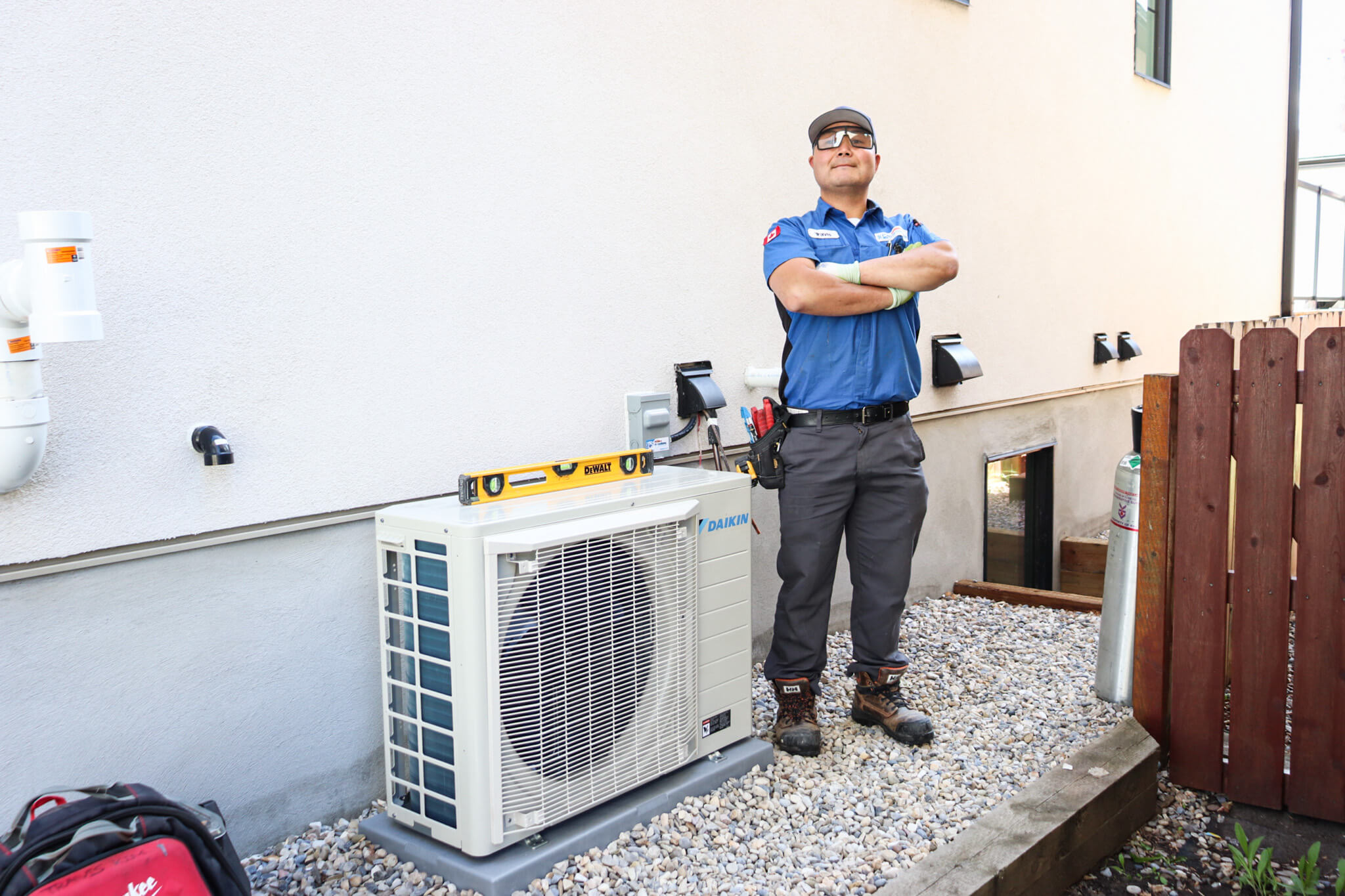 HVAC Technician standing next to a Daikin AC